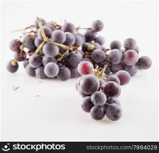 Black grape over white background, horizontal image