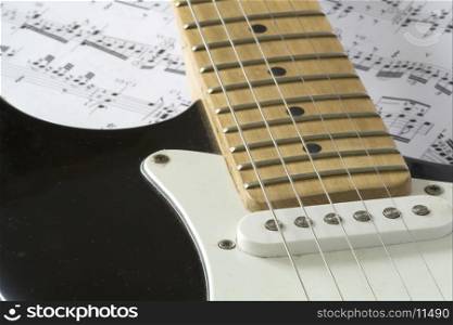 black guitar resting on notes