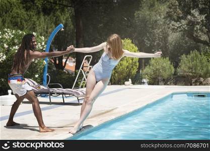 black guy with dreadlocks playing in a pool with caucasian girl
