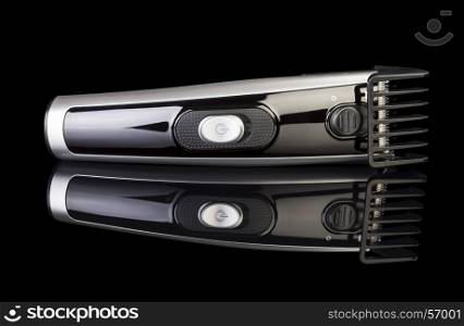 Black hair clipper isolated on black background.