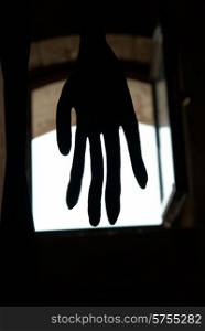 Black hand in front of the window