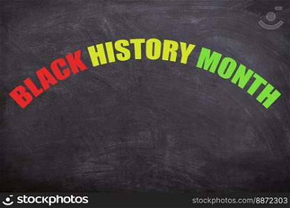 Black history month text in three different colors with a blackboard background. African and American culture. This image is about Black history month, equality, freedom, no racism, and African.