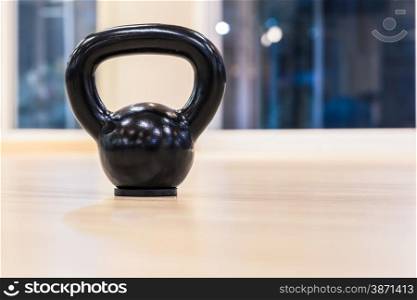 black iron kettlebell weight on wooden floor