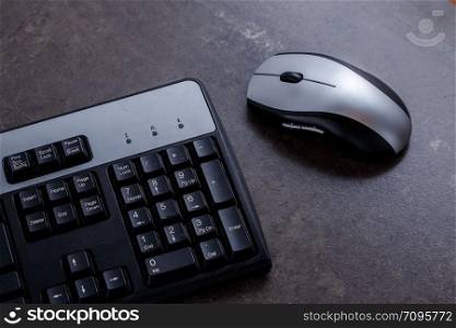 black keyboard and black and grey computer mouse on grey marble