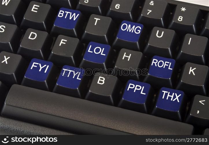 Black keyboard with text message slang words on keys including LOL, OMG, BTW, ROFL, FYI, TTYL, PPL and THX to illustrate fast paced social networking lifestyle concept.