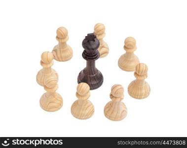 Black King surrounded by white pawns. Wooden chess piece on chessboard