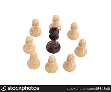 Black King surrounded by white pawns. Wooden chess piece on chessboard