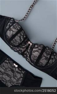 black lace female underwear on a gray background, top view. underwear on a gray background