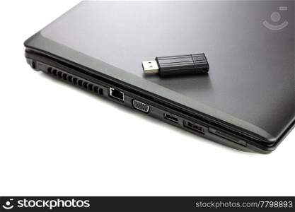 black laptop and flash drive isolated on white