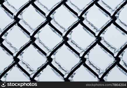 Black large chain-link fence covered in ice on white background.