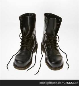 Black leather boots with laces untied.