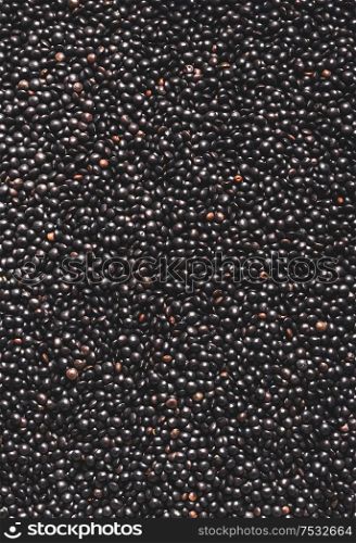 Black lentils background. Protein rich vegan foods. Plant based protein source. Top view. Texture