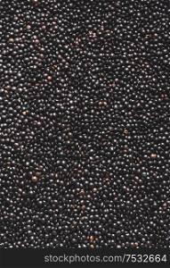 Black lentils background. Protein rich vegan foods. Plant based protein source. Top view. Texture