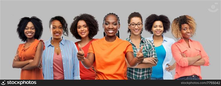 black lives matter, social and people concept - group of happy african american women showing thumbs up gesture over grey background. happy african american women showing thumbs up