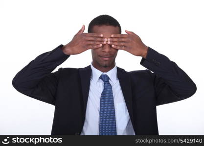 Black man covering his eyes