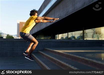 Black man doing squats with jumping on a step as a workout for his legs.. Black man doing squats with jumping on a step.