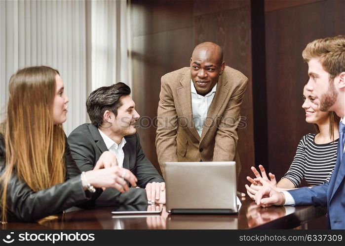 Black man explaining his project to the working group. Businesspeople, teamwork. Group of multiethnic busy people working in an office