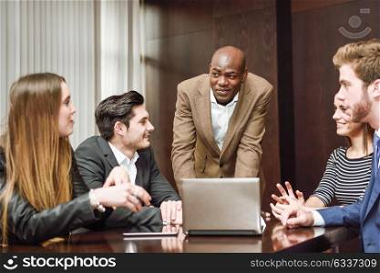 Black man explaining his project to the working group. Businesspeople, teamwork. Group of multiethnic busy people working in an office