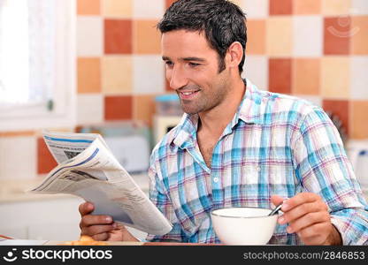 Black man having breakfast with newspaper
