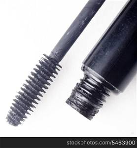 Black mascara and brush isolated on white. Cosmetic detail close up