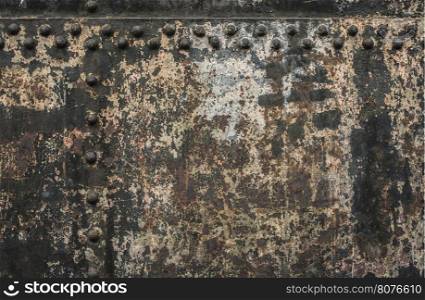 Black metal wall with rivets