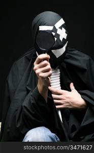 Black mime with rope on neck and magnifier on black background