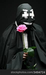 Black mime with rope on neck and rose on black background