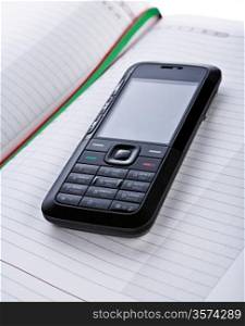 black mobile phone on a notepad