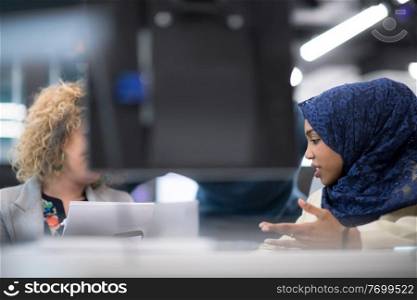 black muslim female software developer working together with her multiethnics business team using computer while writing programming code at modern startup office