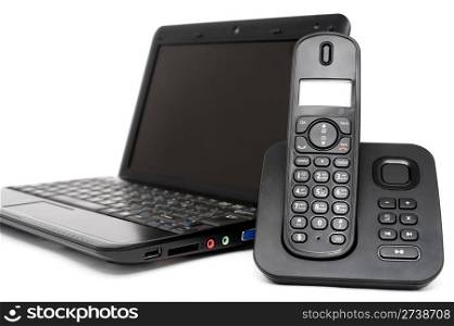 black netbook and decked telephone over white background