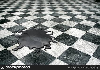 Black oil spilled on checkered marble floor. Oil spill disaster concept