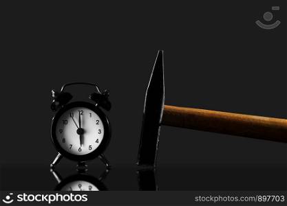 Black old style alarm clock isolated. wake up with a hammer on a black background. wake up with a hammer on a black background. Black old style alarm clock isolated