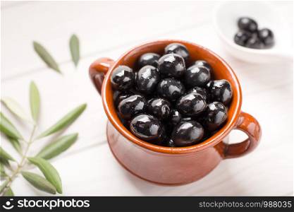 Black olives on rustic bowl. Tasty spanish appetizer