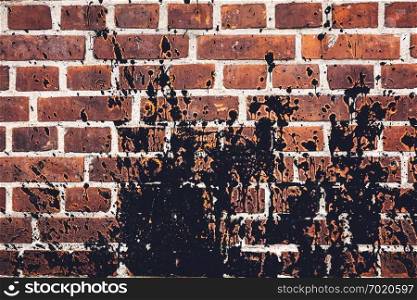 Black paint spilled all over red brick wall. Grunge background.. Black paint spilled all over red brick wall.