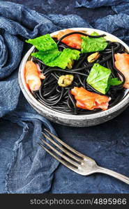 black pasta with mussels and trout. plate of black spaghetti with black mussels and and trout