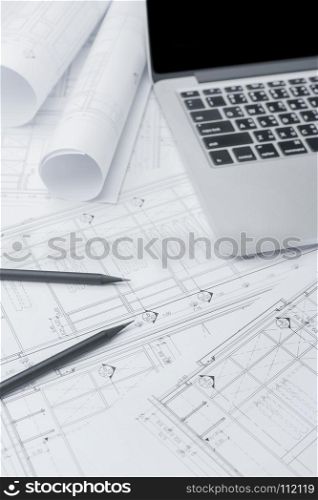 black pencil and computer laptop on architectural drawing paper for construction
