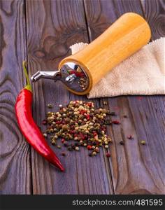 Black pepper corns, red hot chili pepper and Black pepper Powder on wooden background