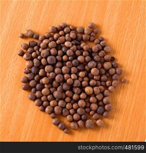black pepper in bulk on a yellow table