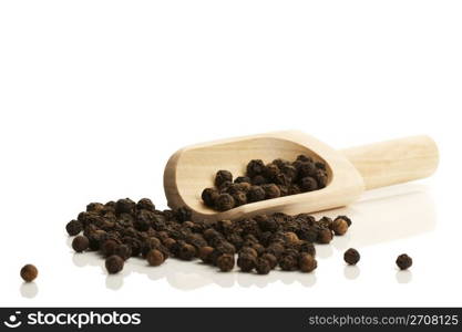 black peppercorns with a small wooden shovel side. black peppercorns with a small wooden shovel from side on white background