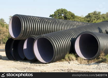 Black pipes and piles of sand in the background.