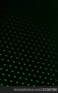 Black plastic mesh texture backlit with green light.