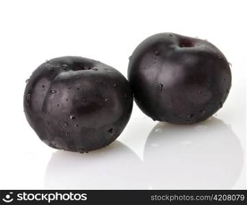 black plums , close up on white background