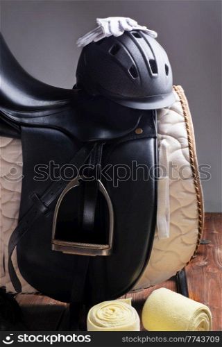 Black professional  leather dressage saddle in complete with riding helmet and gloves  puted at saddle rack travel