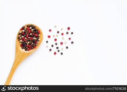 Black, red and white peppercorns on white background.