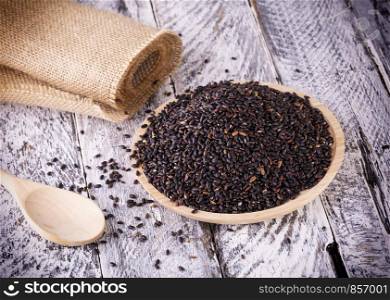 Black rice on the old wooden background