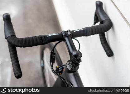 Black road bike handlebar with brake levers and cables