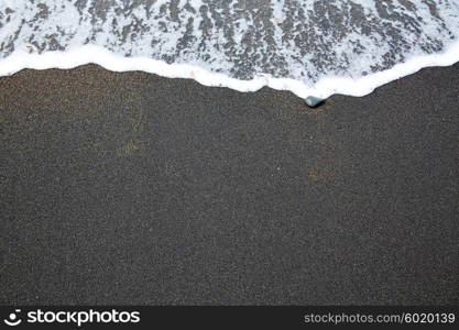 Black sand beach with wave foam texture in Fuerteventura at Canary Islands