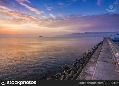 Black sea at a beautiful sunrise, breakwater and ship in the light of the rising sun, Varna, Bulgaria