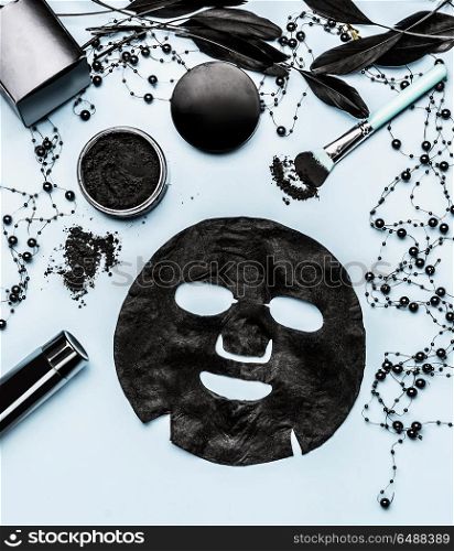 Black sheet mask and cosmetic products setting with Activated Charcoal, top view. Beauty and modern skin care concept. Branding mock up