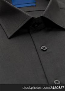 black shirt with a focus on the collar and button, close-up. cotton shirt, close-up